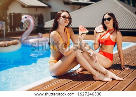 Beautiful girls on a vacation. Friends in the swimming pool