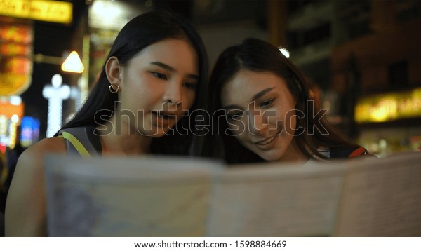 Beautiful\
girls are reading the map on the\
roadside.