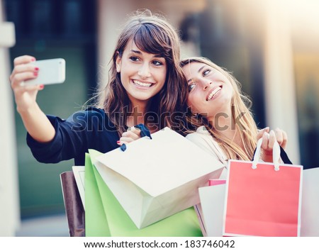 Beautiful girls with shopping bags taking a 