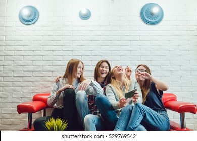 Beautiful Girls Sitting On The Couch And Have Fun In Hostel