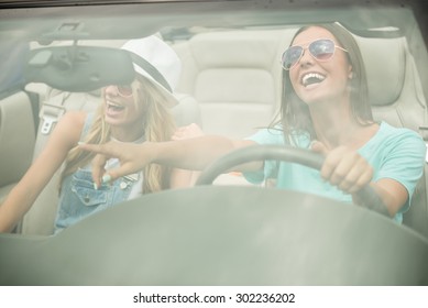 Beautiful Girls In Sunglasses Driving On Cabriolet, Looking Away And Having Fun.