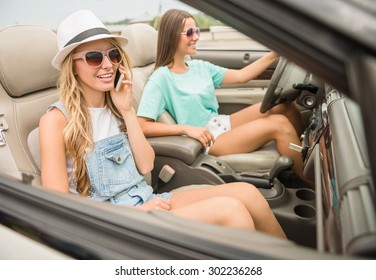 Beautiful Girls In Sunglasses Driving On Cabriolet. Blonde Talking By Phone.