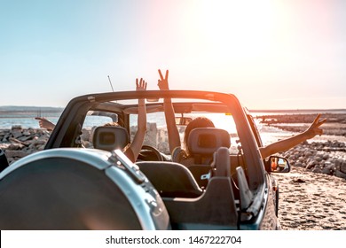 Beautiful girls and young people traveling with jeep car in a sunset in a beach landscape - Powered by Shutterstock