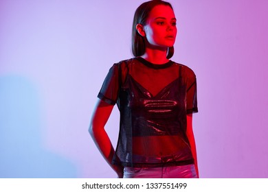 Beautiful Glamor Woman In Silver Lake And In A Transparent T-shirt Purple Disco Party Background