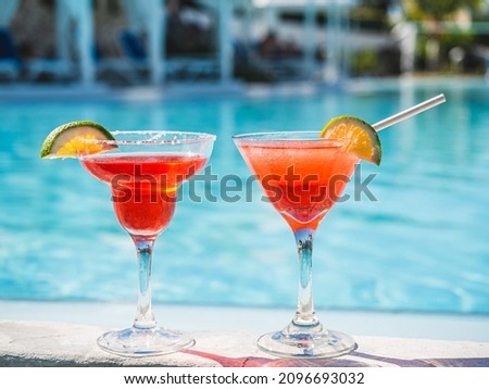 Beautiful glass with a refresh cocktail on the background of the swim pool. Top view, close-up. Vacation and travel concept. Moments of celebration
