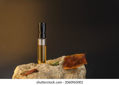 Beautiful Glass Sprayer Bottle Standing On A Stone With Apple Leaves. Autumn Cosmetic Concept Composition. Wooden Scent Perfume Sample Presentation. Luxury Product Advertising Concept Or Mockup