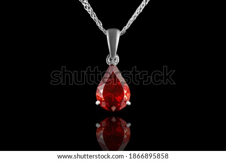 beautiful gold pendant with gemstones garnet and diamonds on a black background close-up