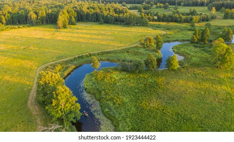 Beautiful Golden Hour Aerial Image Of The Winding River And In The Middle Of Floodplain In Soomaa NP With The Distant Canoe Hikers On Water 