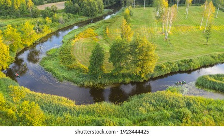 Beautiful Golden Hour Aerial Image Of The Winding River And In The Middle Of Floodplain In Soomaa NP With The Distant Canoe Hikers On Water 