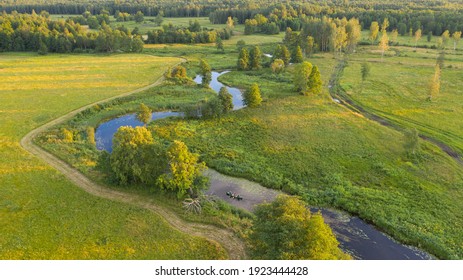 Beautiful Golden Hour Aerial Image Of The Winding River And In The Middle Of Floodplain In Soomaa NP With The Distant Canoe Hikers On Water 