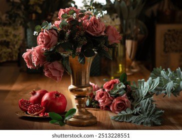 Beautiful golden vases with artificial flowers and pomegranates, on wooden table, household items, retro