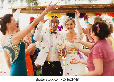 beautiful  gorgeous blonde bride  and stylish groom under confetti, hawai  colorful sand ceremony  on cyprus
