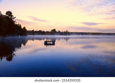 Beautiful gorgeous stunning landscape Ontario Canada cottage country. Pastel pink purple blue. Calm still lake water reflection sky trees. Floating dock. Sunrise sunset dawn twilight rising mist misty - Powered by Shutterstock