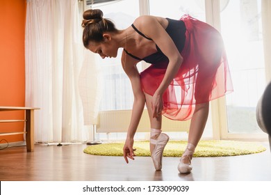 Beautiful Graceful Woman Wear Nude Color Dancing Pointe Shoes With Ribbons And Transparent Red Skirt, Classic Ballet At Home During Pandemic Lockdown