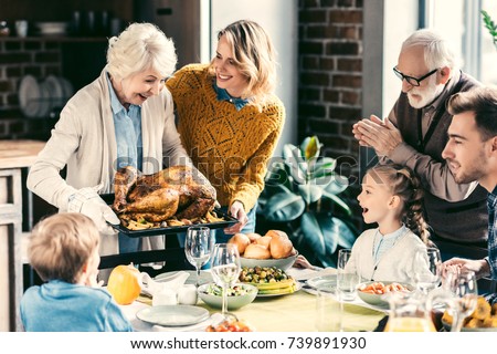beautiful grandmother carrying turkey for family on thanksgiving dinner