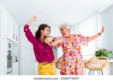 Beautiful grandmother and granddaughter dancing together at home - Cheerful granma and nephew spending quality time together - Powered by Shutterstock