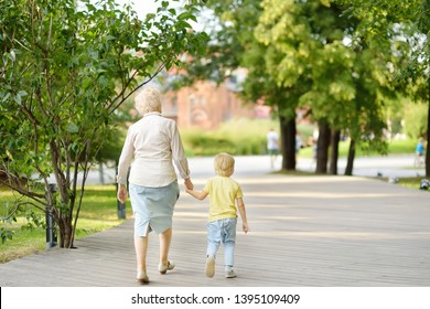 Beautiful granny and her little grandchild walking together in park. Grandma and grandson - Powered by Shutterstock