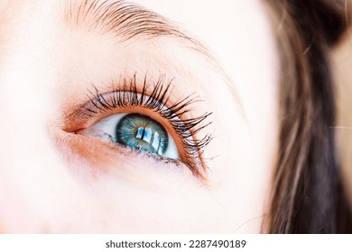 Beautiful gray-blue eyes with long lashes. Young woman, a girl is looking up. Dreaming, praying, turning to God concept. Visual gymnastics for improving vision. Female look on a sky with a hope.