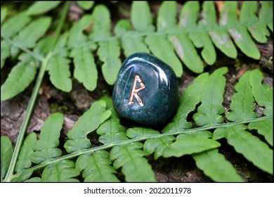 Beautiful green Raido Rune made of bloodstone with fern background