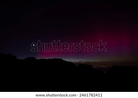 A beautiful green and red aurora borealis dancing over the swiss alps in the heart of Switzerland during a big sunstorm.