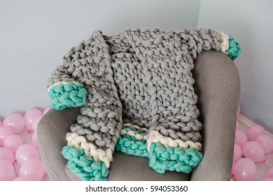 Beautiful Grey And Blue Merino Wool Jacket On Grey Arm Chair And Balloons On Floor