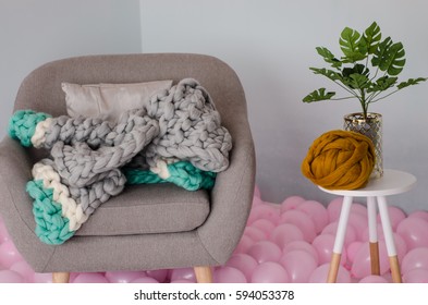 Beautiful Grey And Blue Merino Wool Jacket On Grey Arm Chair And Balloons On Floor