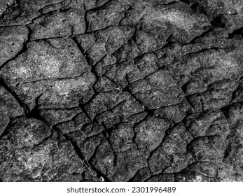 Beautiful grey surface stone texture background, black and white style. The strong rock cracked. The jagged surface of the large rocks on the beach.