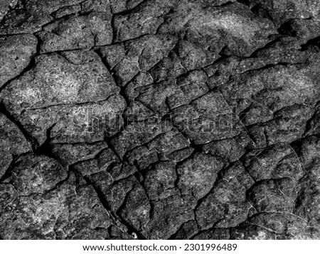 Beautiful grey surface stone texture background, black and white style. The strong rock cracked. The jagged surface of the large rocks on the beach.