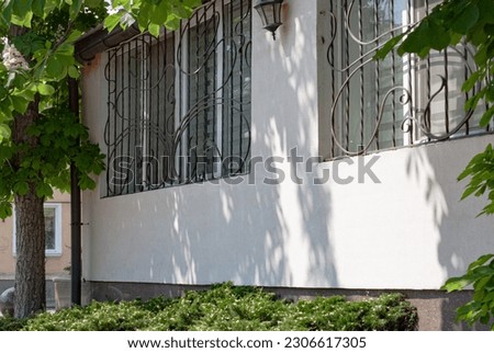 А beautiful grid on a metal-plastic window. Forged window grill. Monograms on the window grill. Сток-фото © 