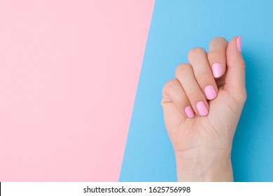 Beautiful Groomed Woman Hand With Light Pink Nails On Pastel Blue Table Side. Two Colors Background. Closeup. Manicure, Pedicure Beauty Salon Concept. Empty Place For Text Or Logo. 