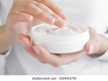 Beautiful Groomed Woman Using Moisturizing Cream For Clean And Soft Skin. Cream Jar In Hands. Healthcare Concept.