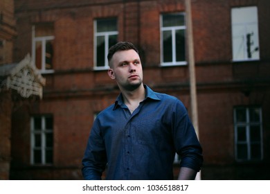 beautiful guy on the street in the shirt near the building - Shutterstock ID 1036518817