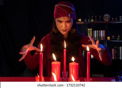 Beautiful Gypsy Fortune Teller Woman Casting A Magical Spell Over Candle While Predicting The Future. Divine Magic, Forecast Esoteric Astrology Superstition, Magical Power, Alchemy, Black Magic.