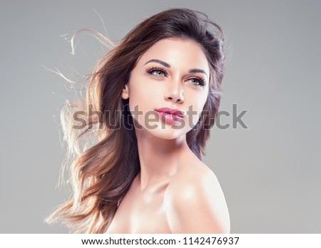 Beautiful hairstyle woman with brunette curly hair and beauty face over gray background female girl portraitgirl