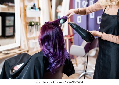 Beautiful hairstyle of young adult woman with purple hair in hair salon.