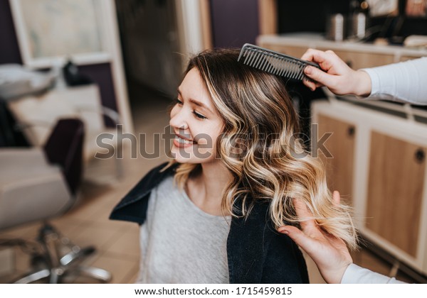 Beautiful hairstyle of young woman after\
dyeing hair and making highlights in hair\
salon.