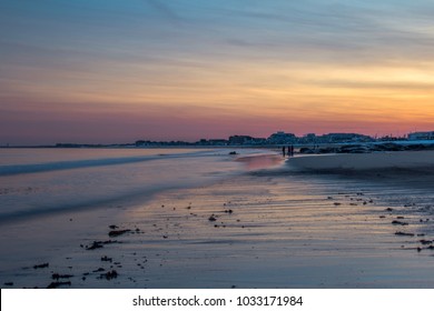 Beautiful Hampton Beach NH Golden Hour Sunset With Pinky Blue Sky And Waves Rolling Onto The Sandy Beach. 