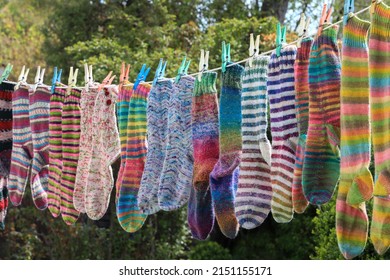 Beautiful Hand Knitted Socks Are Hanging On A Clothes Washing Line Outside To Dry Eco Friendly In The Wind And Sunshine.