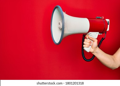 Beautiful Hand Of Man Holding Megaphone Over Isolated Red Background