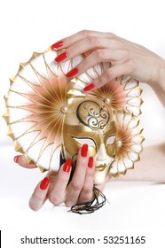 Beautiful hand with perfect red manicure holding carnival mask. youth and beauty concept