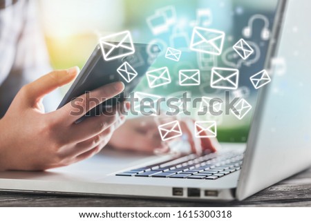 Beautiful hand working on a laptop with email icons