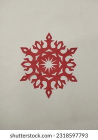 A beautiful handcrafted paper snowflake design in red colour on white background  - Shutterstock ID 2318597793