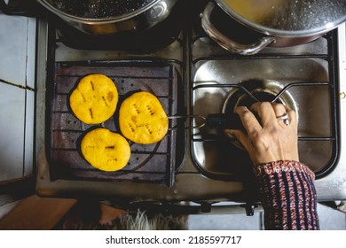 Beautiful Hands Of Elderly Latino Woman Cooking On Traditional Kitchen Stove With Gas Burners With Traditional Toaster With 'sopaipillas' (fried Pastry) And Pots (view From Above)