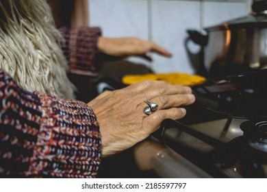 Beautiful Hands Of Elderly Latino Woman Cooking On Traditional Kitchen Stove With Gas Burners With Traditional Toaster With 'sopaipillas' (fried Pastry) And Pots