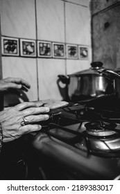 Beautiful Hands Of Elderly Latino Woman Cooking On Traditional Kitchen Stove With Gas Burners With Traditional Toaster With 'sopaipillas' (fried Pastry) And Pots (in Black And White)