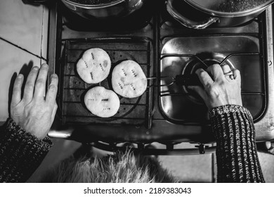 Beautiful Hands Of Elderly Latino Woman Cooking On Traditional Kitchen Stove With Gas Burners With Traditional Toaster With 'sopaipillas' (fried Pastry) And Pots (in Black And White, View From Above)