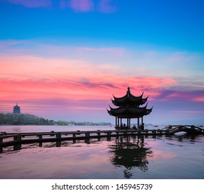 beautiful hangzhou in sunset, ancient pavilion silhouette on the west lake,China - Powered by Shutterstock