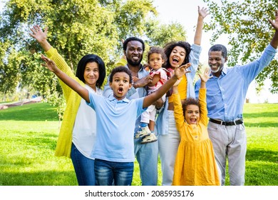 Beautiful Happy African American Family Bonding At The Park - Extended Family Having Fun Outdoors - Kids, Parents And Grandparents Spending Time Together