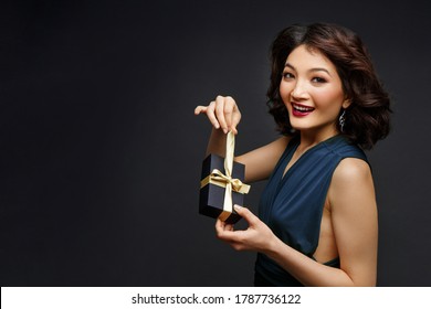 Beautiful Happy Brunette Young Woman Opening Small Present Box. Sexy Look With Red Lips. Studio Beauty Shot. Copy Space.