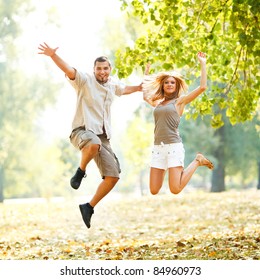 Beautiful happy couple jumping in the park